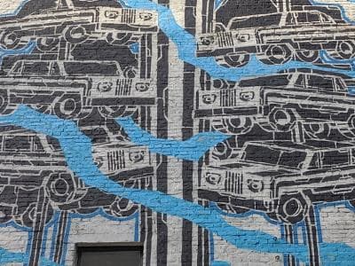 Необычный мурал расположен на боковой стене здания по адресу Стрелецкая, 20. На стрит-арте изображена карусель с автомобилей выполненная в черно-белых тонах с добавлением синего шлейфа.